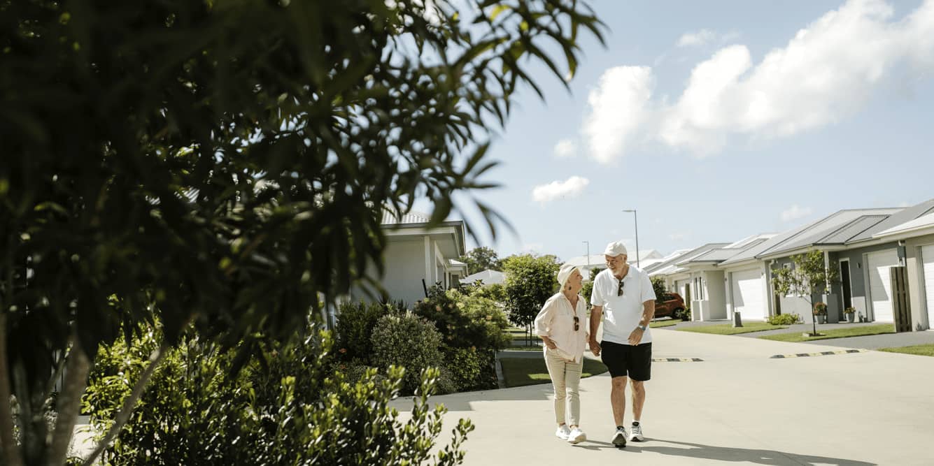 A couple walking hand-in-hand on a street in an Ingenia Lifestyle community.