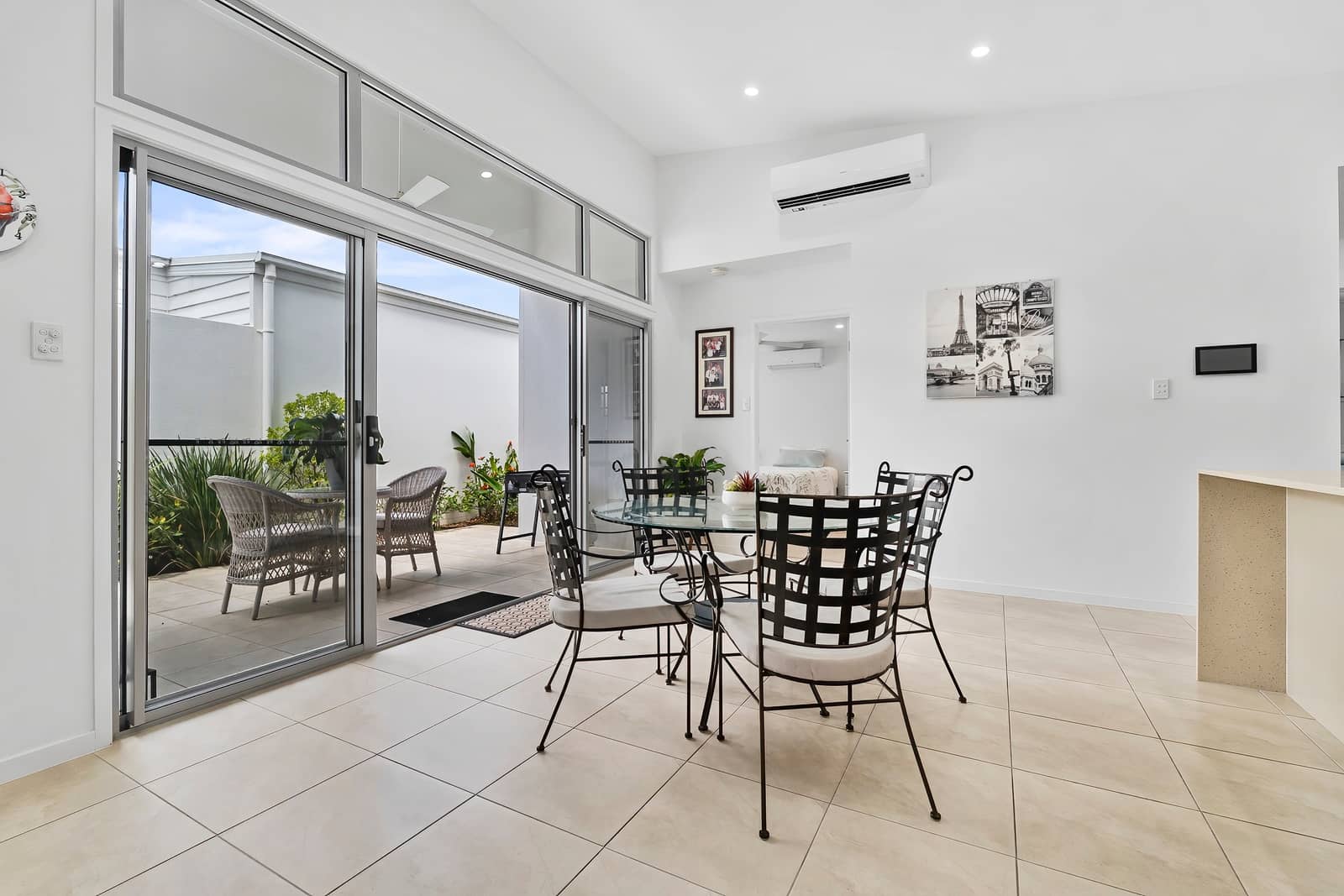 Bright dining area in an Ingenia Lifestyle home, featuring a glass table, tiled floor, and access to a private outdoor patio.