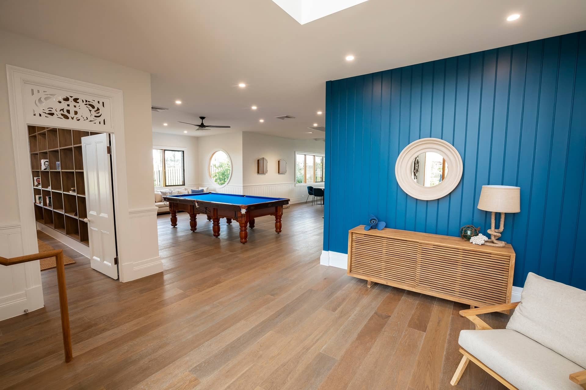 Ingenia Lifestyle shared amenities: a communal room with a blue pool table, lounge seating, and a library area with a blue feature wall.