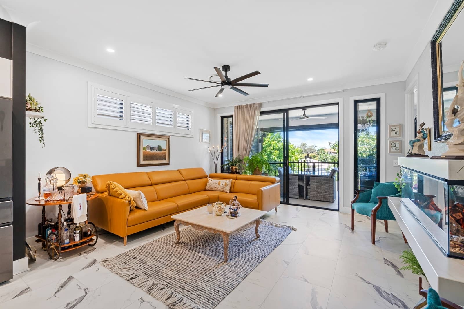 An orange sectional sofa in a living room with a coffee table and a bar cart.