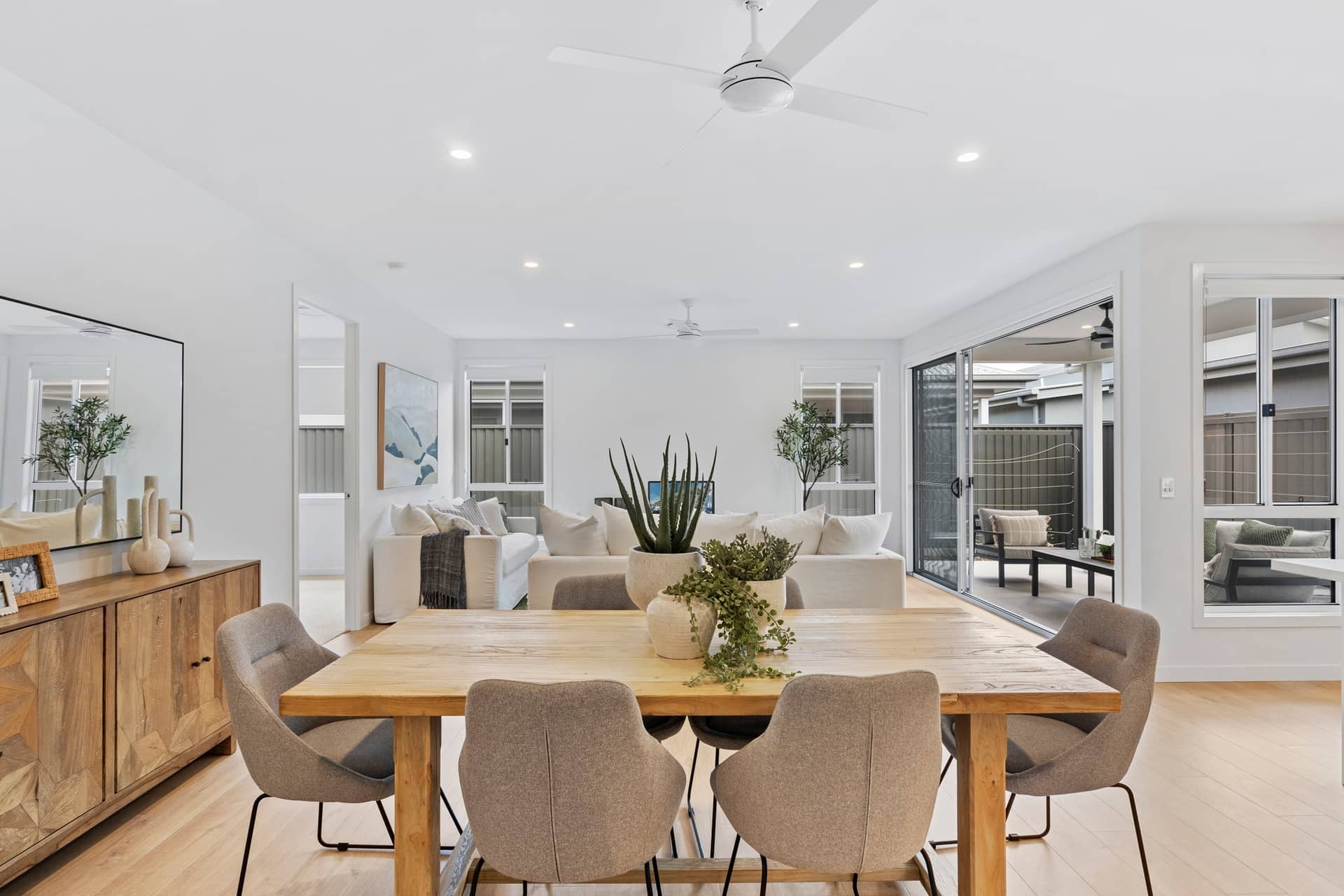 Ingenia Lifestyle open-plan dining and living area with natural wood furniture and neutral tones.