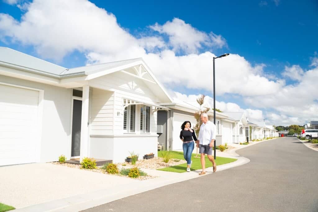 A couple walking on a street in an Ingenia Lifestyle community with land lease homes.