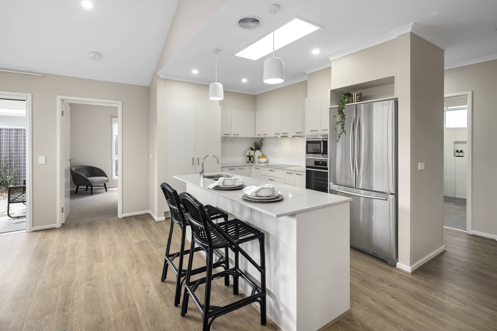 Modern kitchen with island, stainless steel appliances, and neutral cabinetry in an Ingenia Lifestyle community.