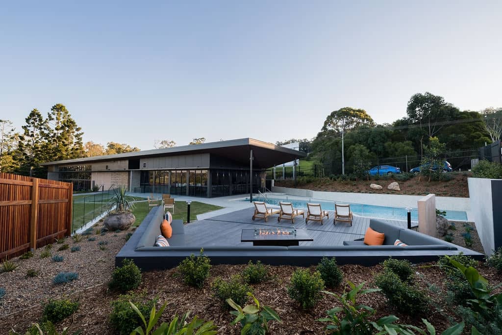 Ingenia Lifestyle community amenity area with a pool, lounge seating, and fire pit.