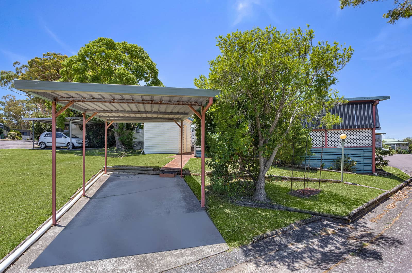 A carport with a concrete driveway sits in front of a land lease home in an Ingenia Lifestyle community.