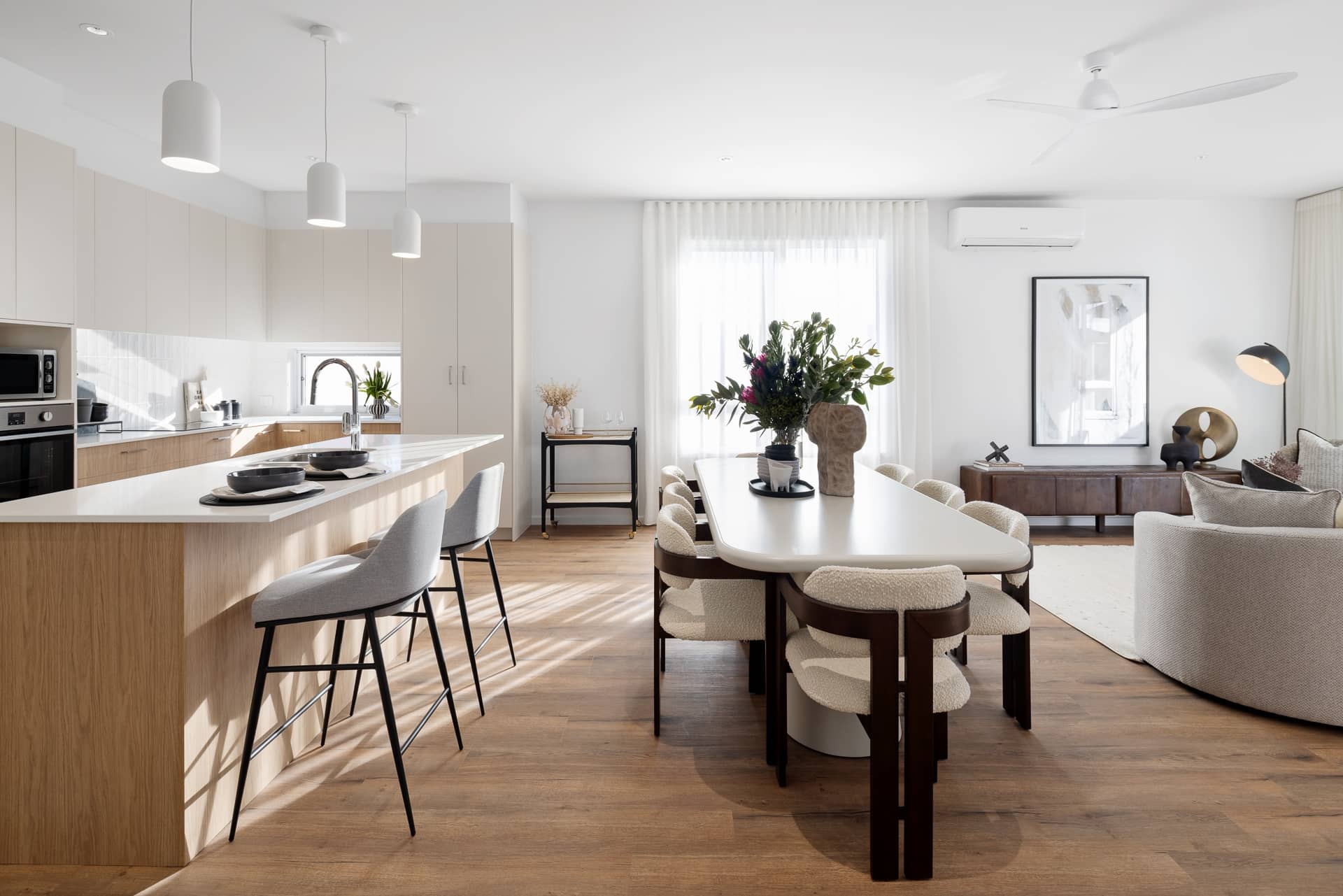 Modern kitchen and dining area with island, chairs, and seating in an Ingenia Lifestyle community.