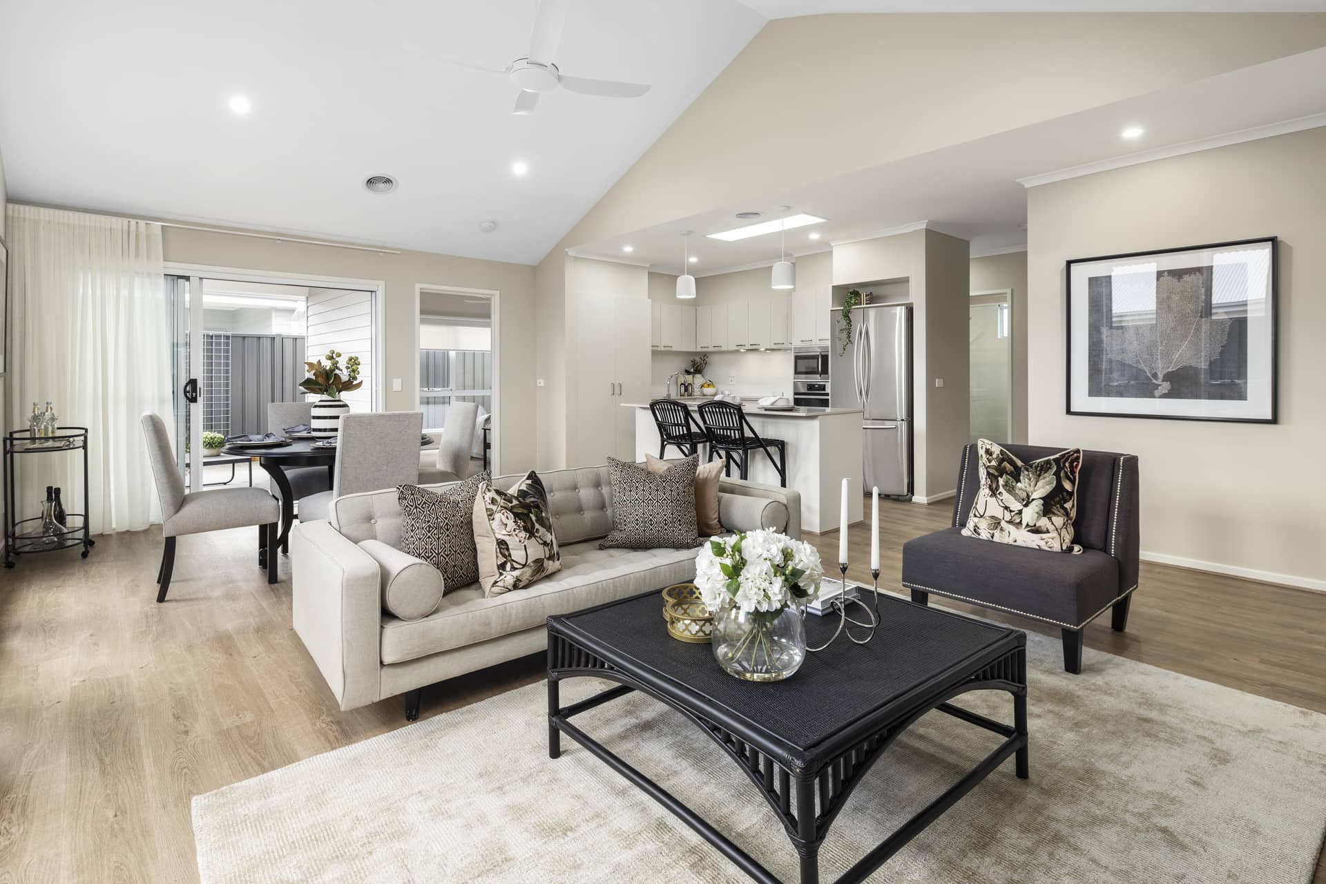 Modern open-plan living area with sofa, coffee table, and kitchen with island.