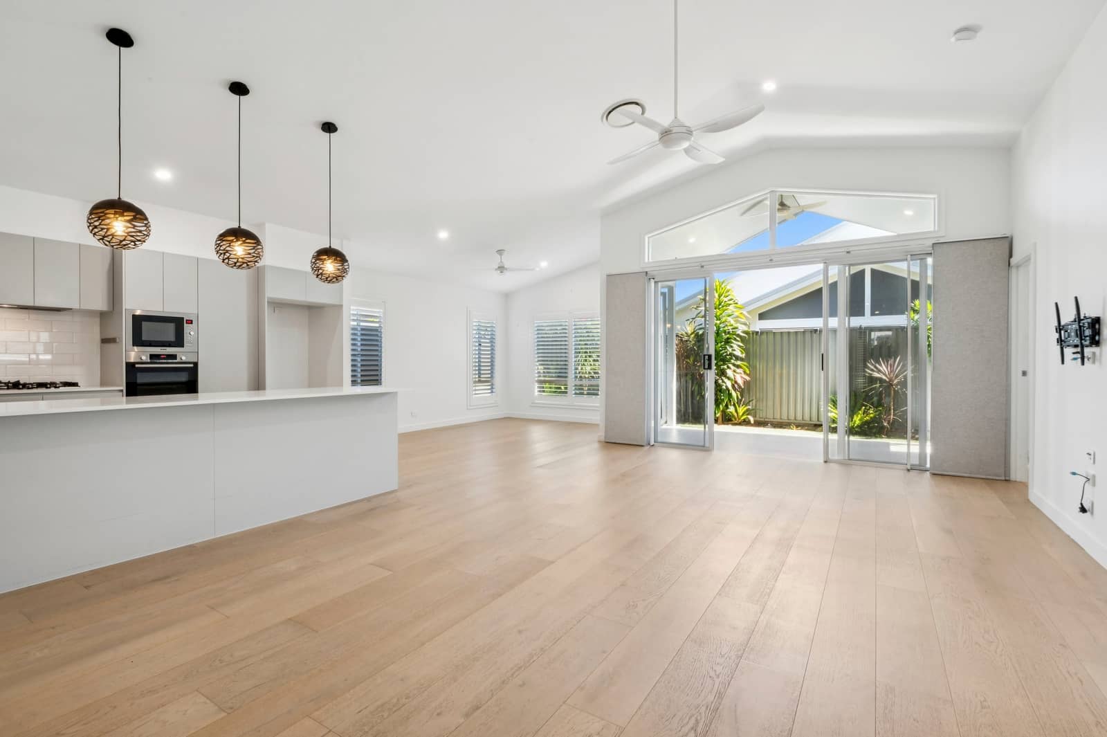 Spacious open-plan living area with kitchen and sliding doors leading to a backyard in an Ingenia Lifestyle community.