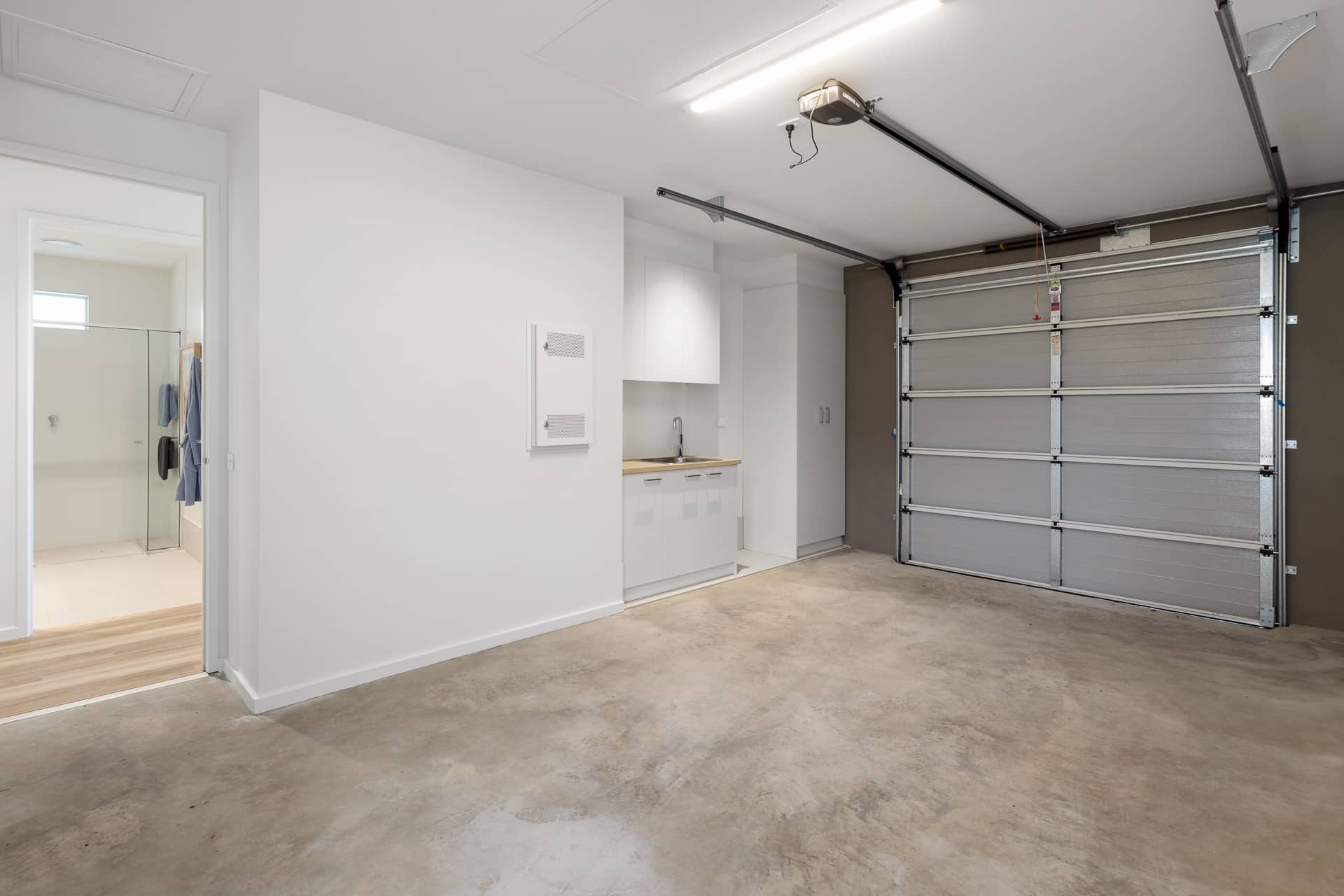 Modern garage in an Ingenia Lifestyle home featuring a laundry area with sink and cabinets, plus direct internal access.