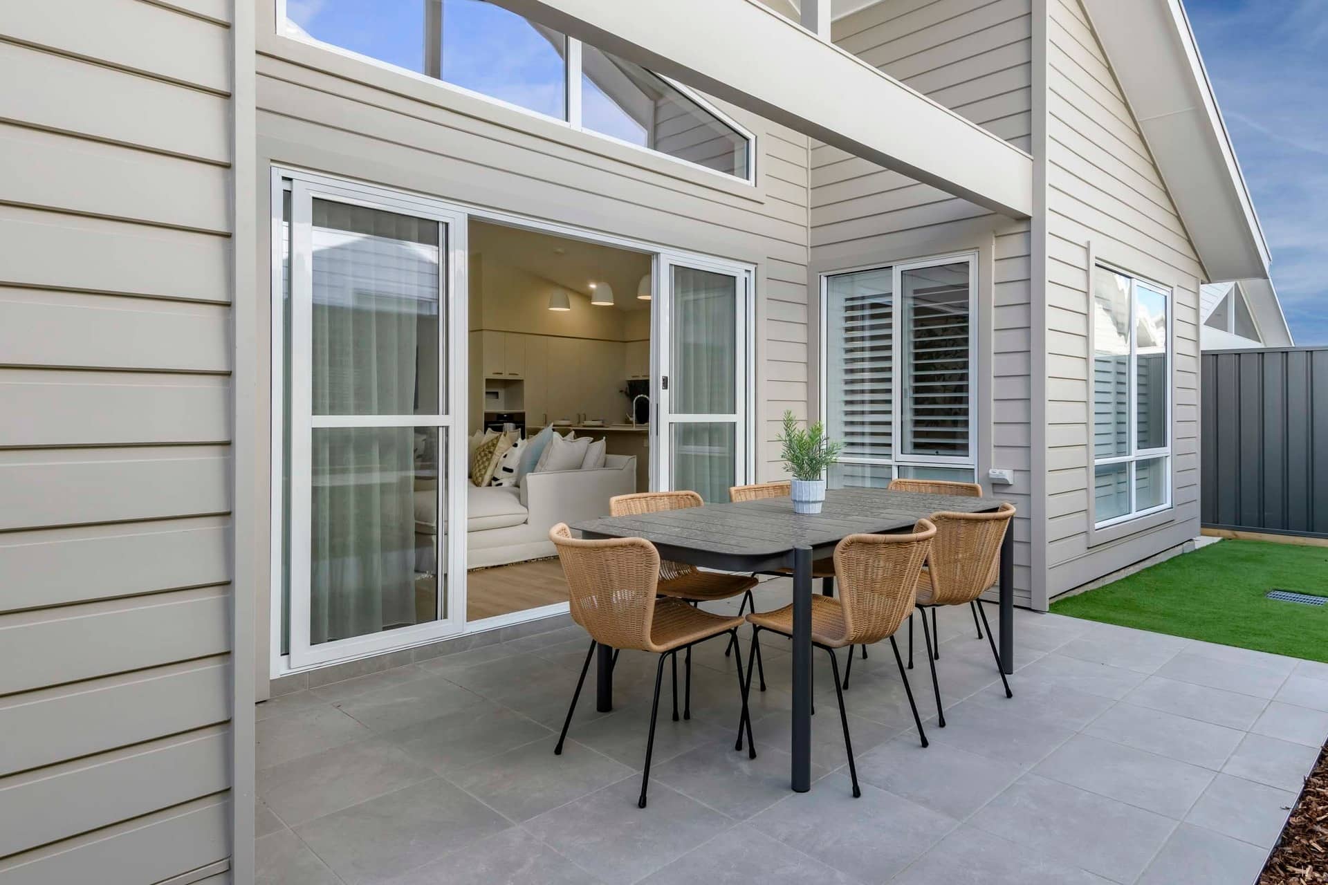 Outdoor dining area with a table and chairs next to a land lease home in an Ingenia Lifestyle community.