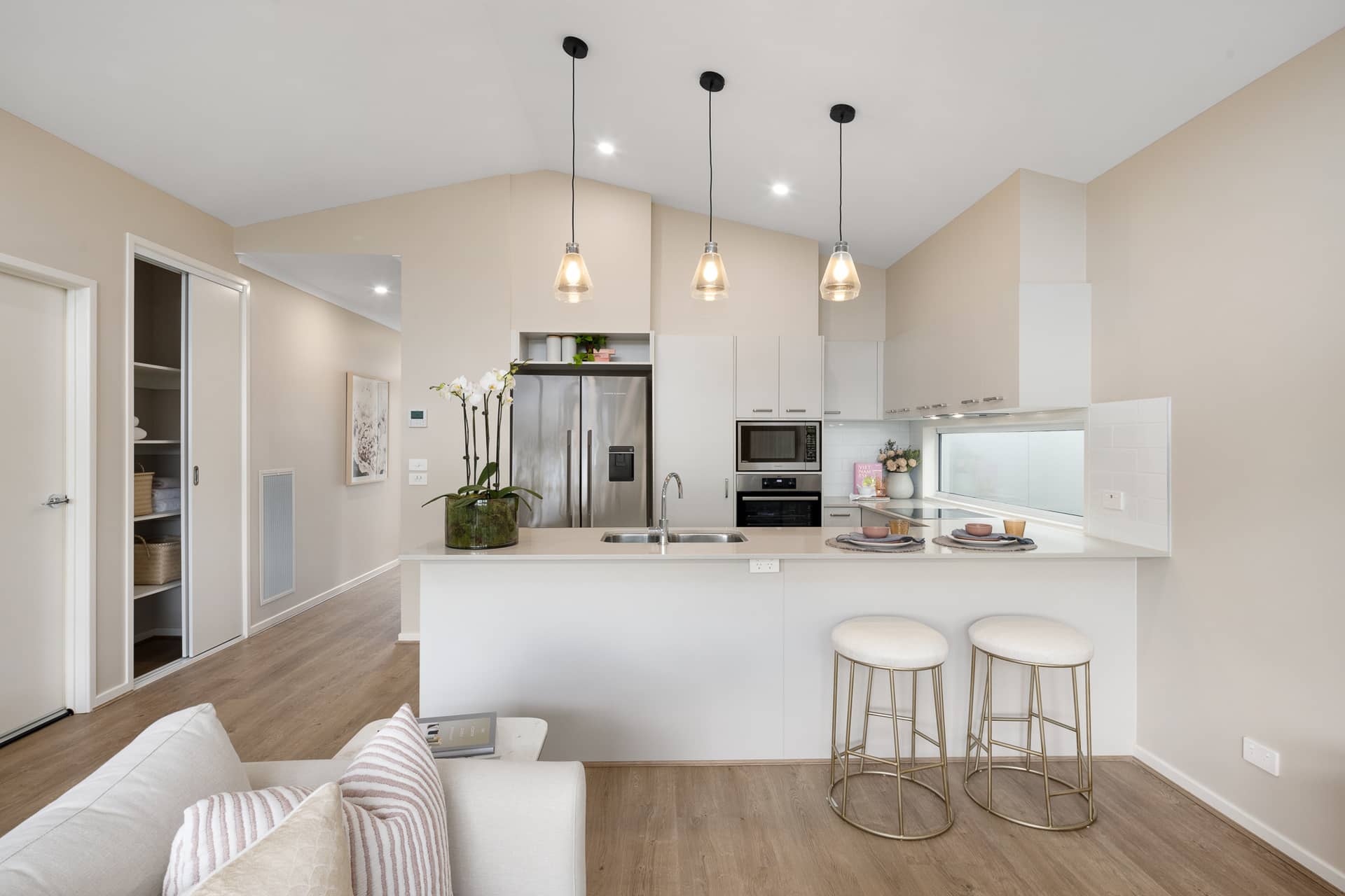 Modern kitchen with stainless steel appliances and island bench with bar stools.