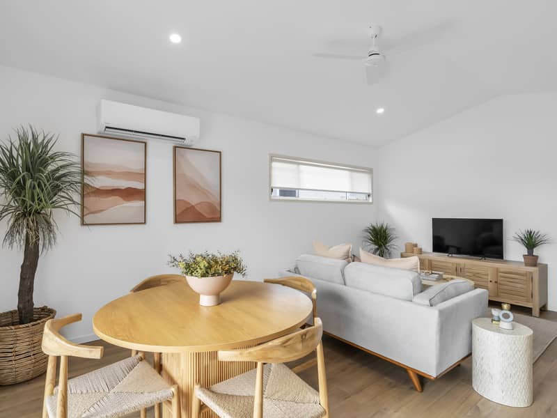 Living area with dining table, chairs, sofa and TV unit in an Ingenia Lifestyle community.