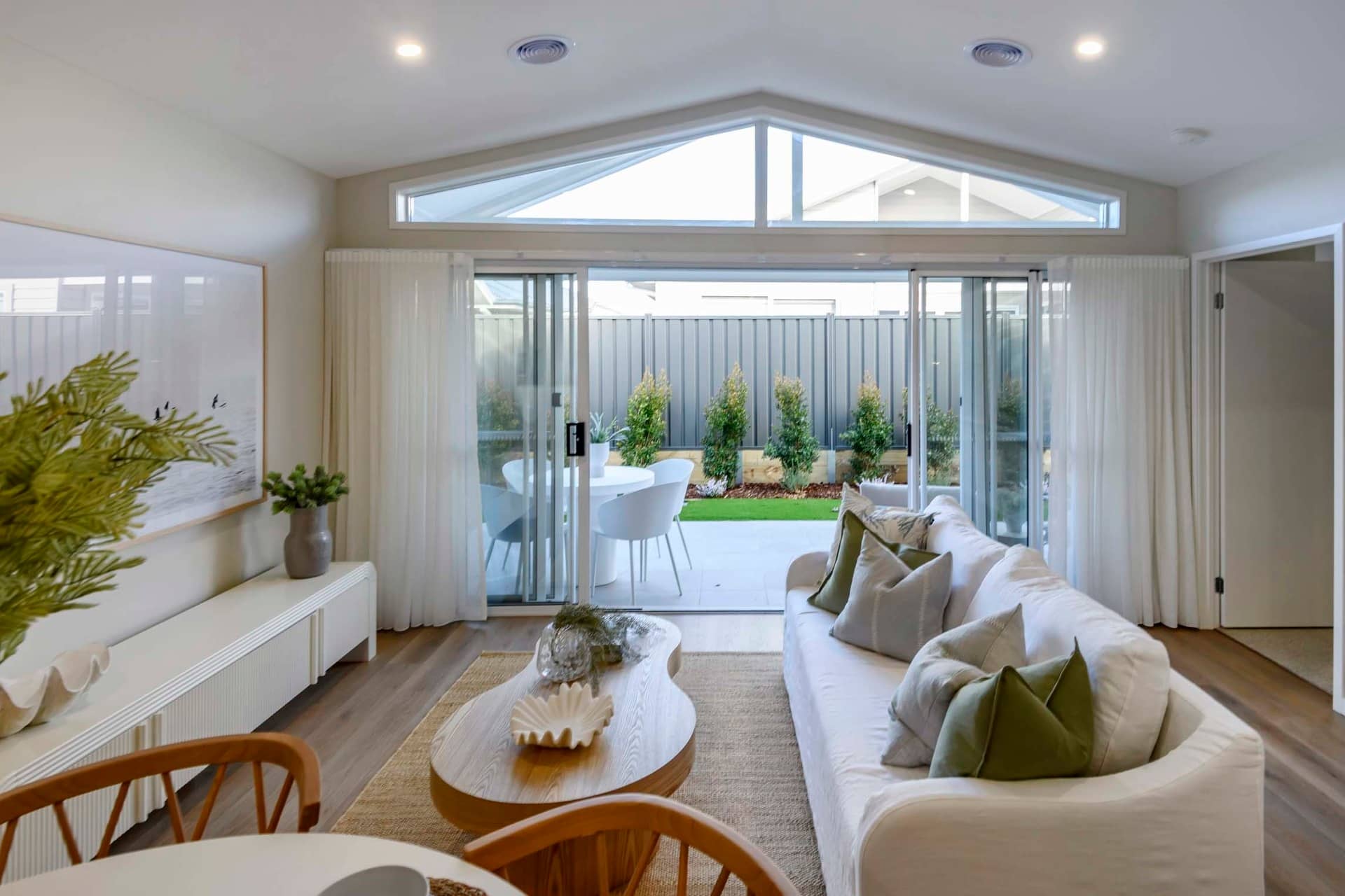 Modern living room with sliding glass doors opening to a patio and garden.