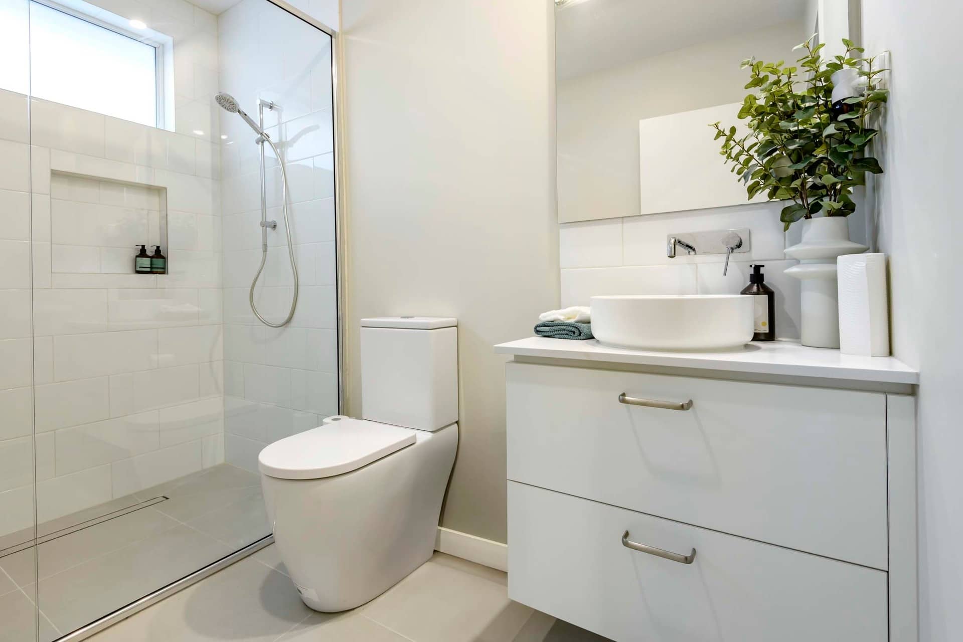 Modern bathroom with a toilet, a glass-enclosed shower, and a vanity with a vessel sink.