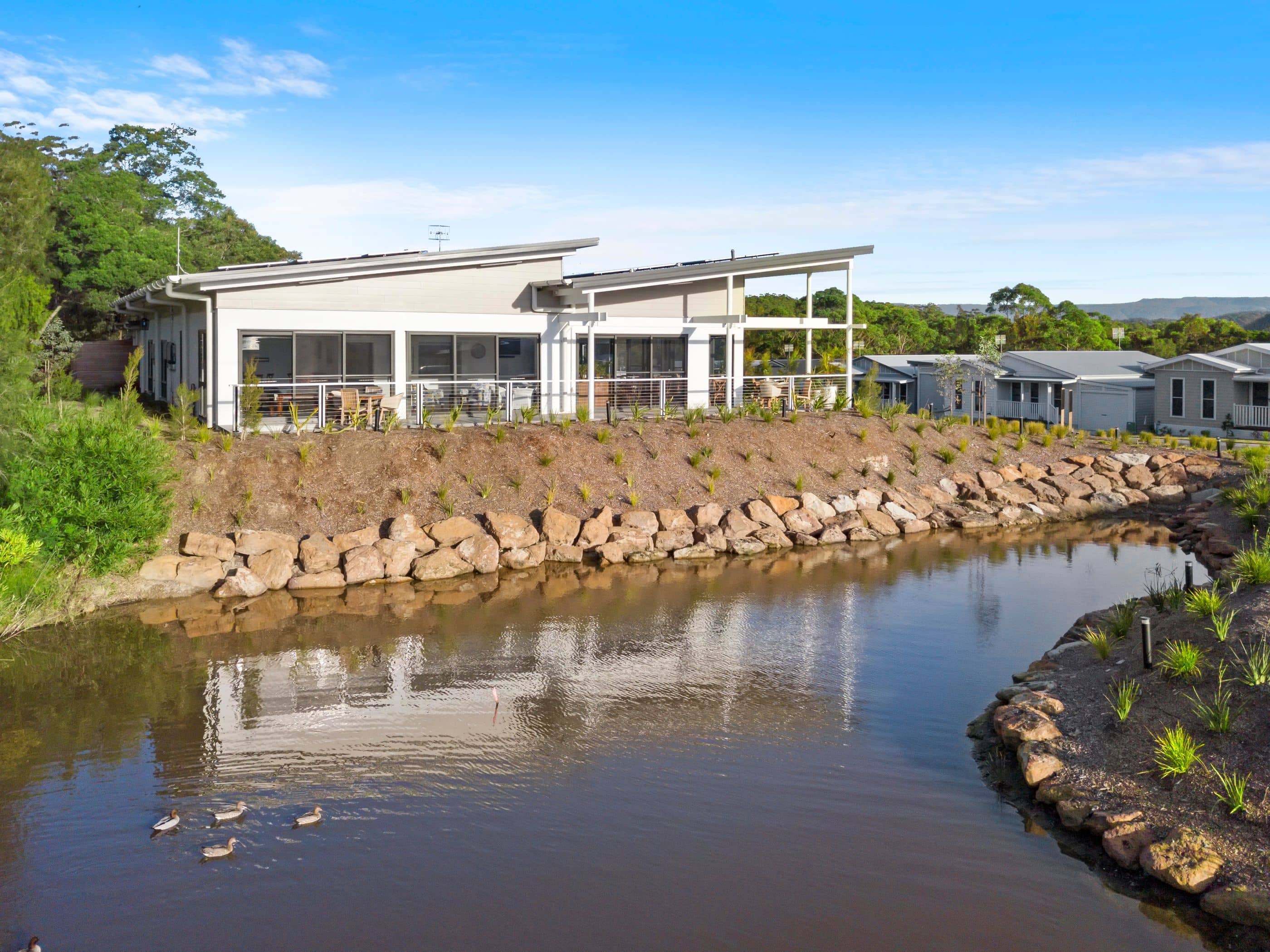 Ingenia Lifestyle community with modern homes and landscaped grounds beside a water feature.