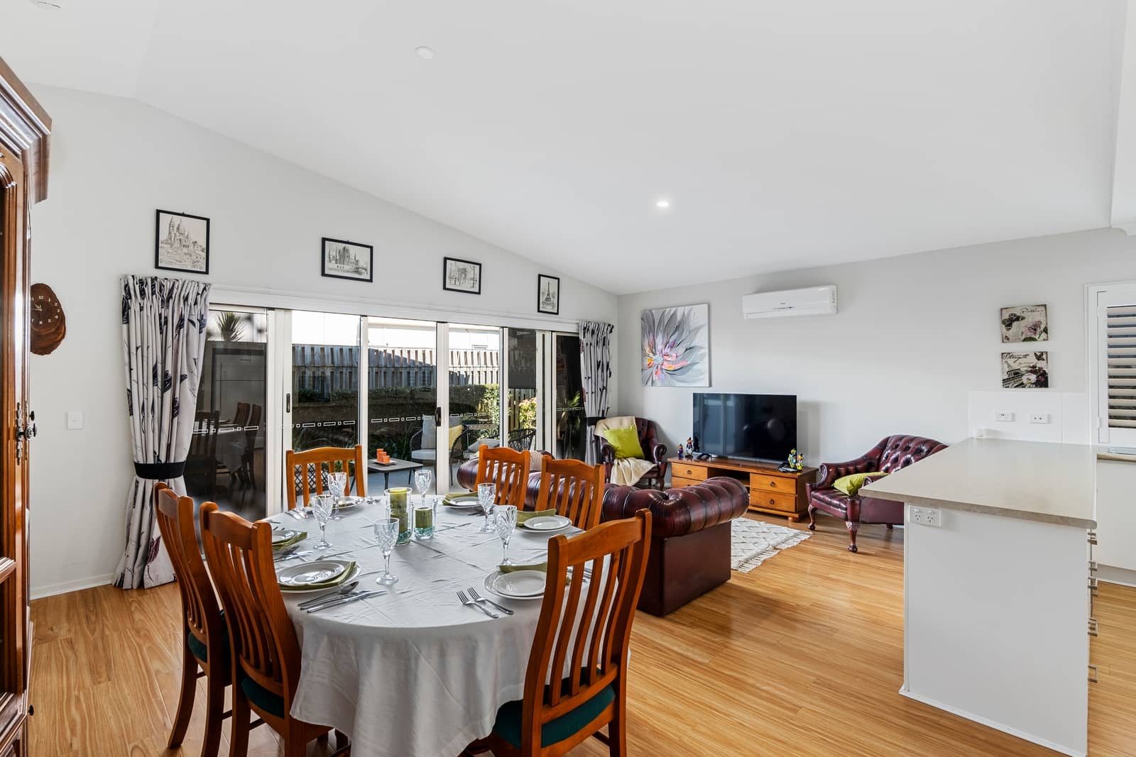 Dining and living area in an Ingenia Lifestyle community home with a set dining table and leather lounge.