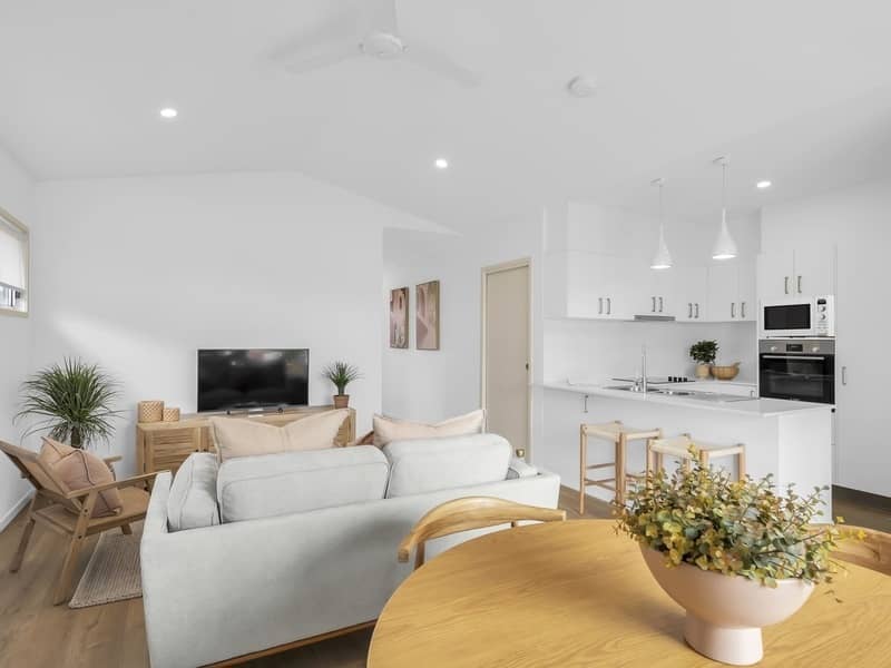 Modern open-plan living and kitchen area with a lounge and dining space in an Ingenia Lifestyle home.