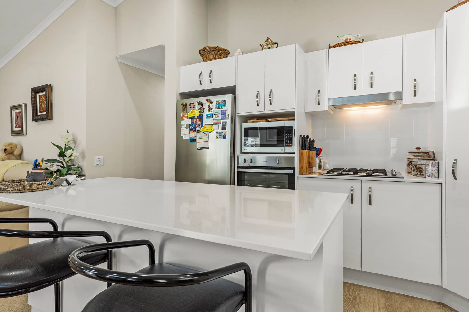 Kitchen with white cabinets, stainless steel appliances, gas cooktop, and a large island bench in an Ingenia Lifestyle home.