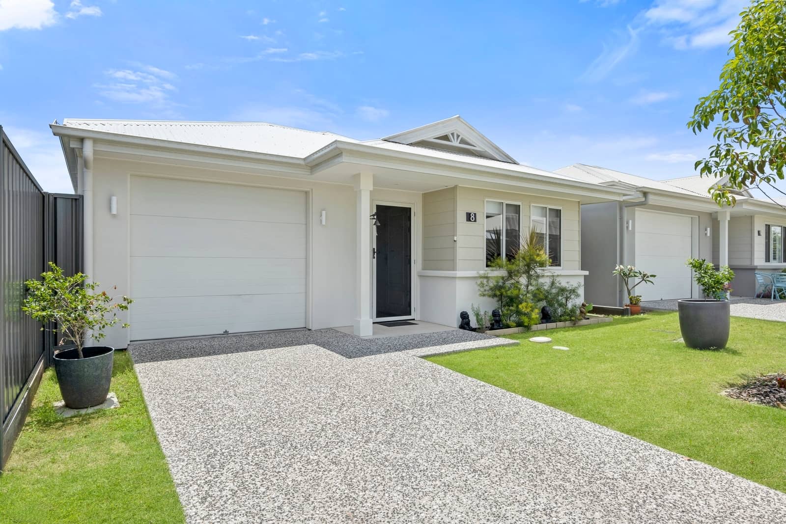 A modern, single-story Ingenia Lifestyle home with an attached garage, paved driveway, and landscaped front garden.