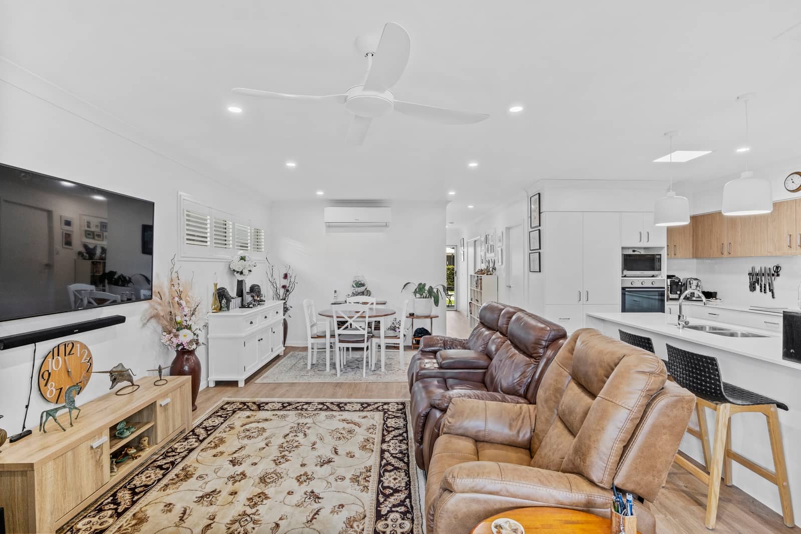 Spacious open-plan living, dining, and kitchen in an Ingenia Lifestyle home with modern finishes and comfortable recliners.