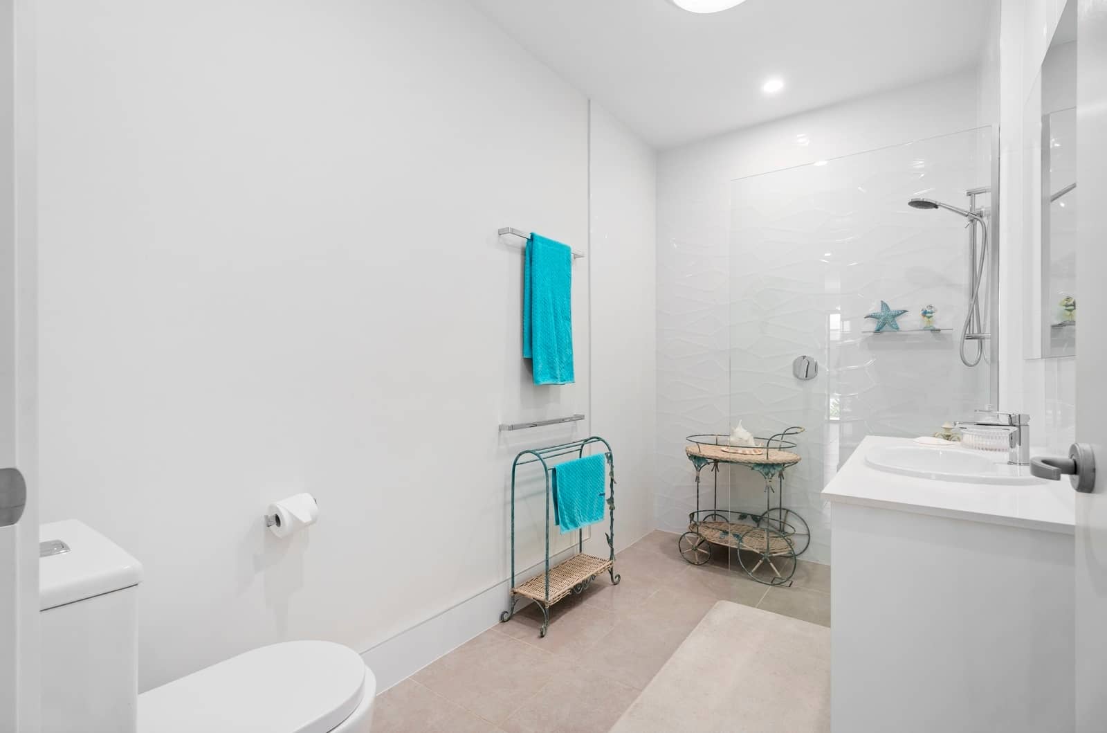 A bright, low-maintenance bathroom in an Ingenia Lifestyle home, with white walls, a walk-in shower, vanity, and toilet.