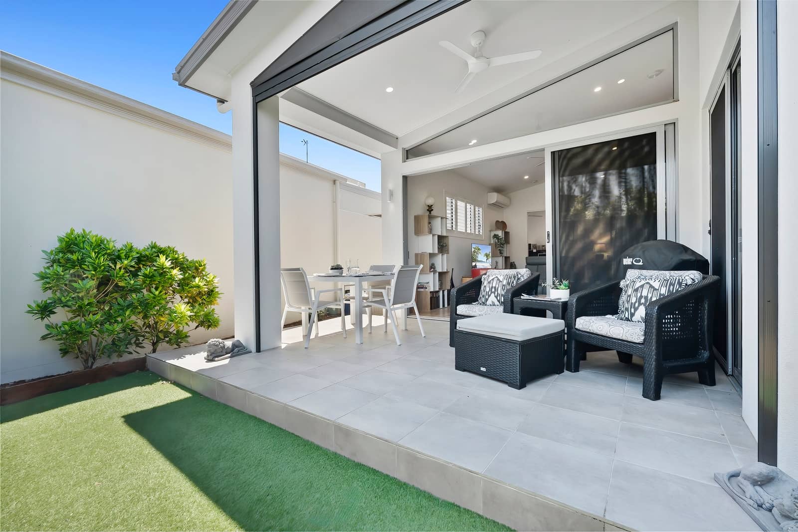 Ingenia Lifestyle home patio with dining and lounge areas, connected to interior living, plus a small garden and artificial turf.