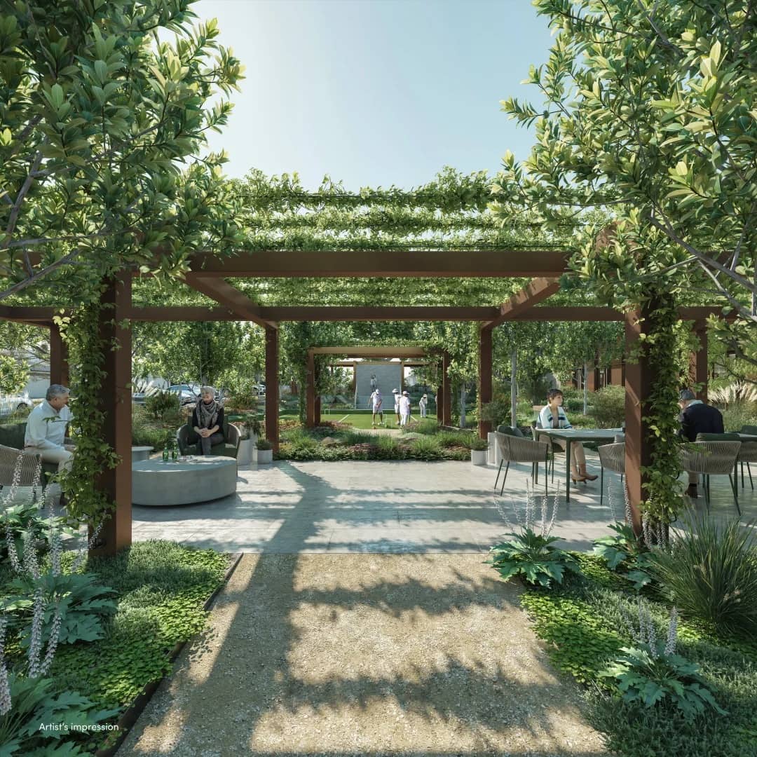 Landscaped Ingenia Lifestyle community garden with pergolas, seating areas, and residents playing lawn bowls.