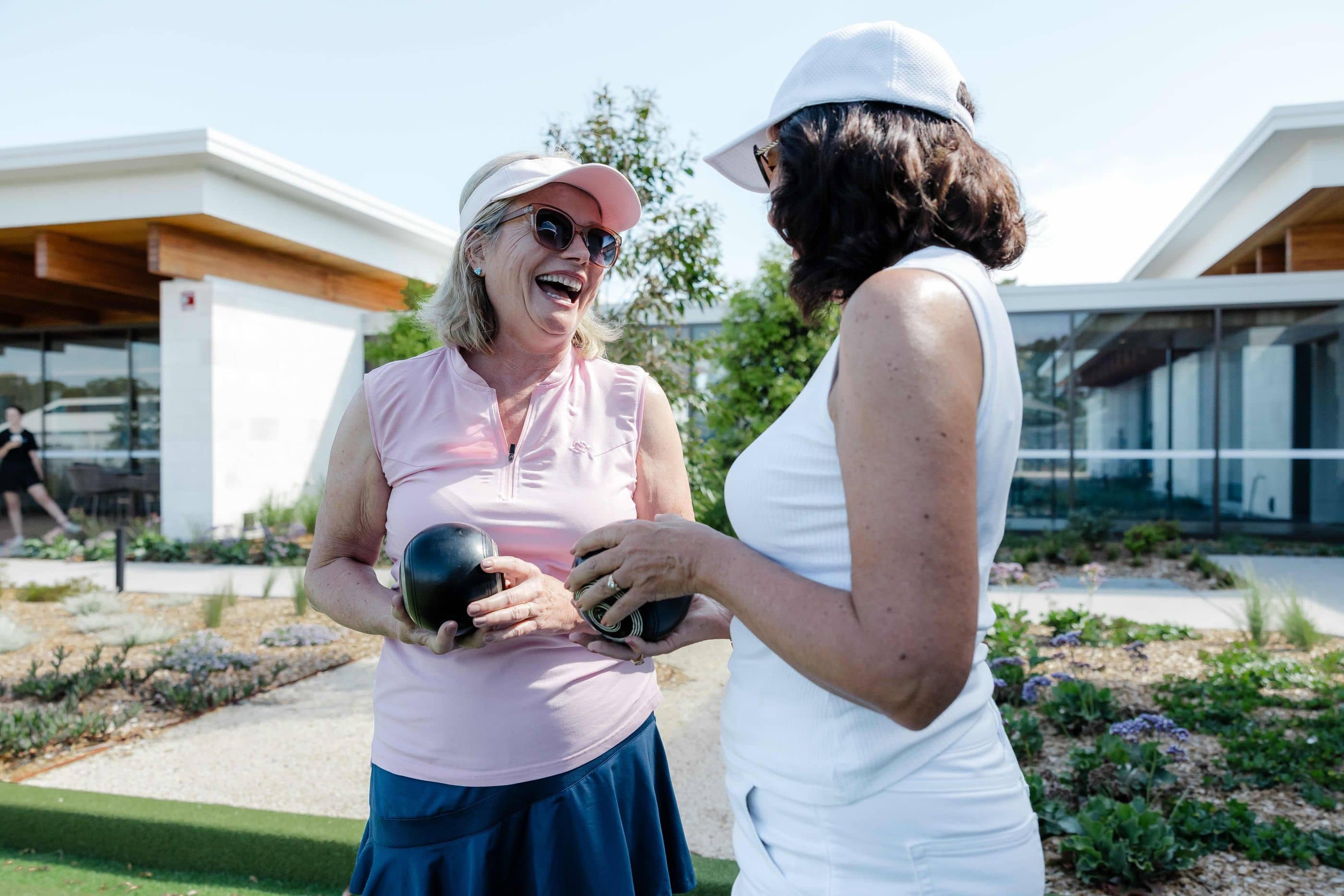 Ingenia Lifestyle residents laughing and playing lawn bowls.