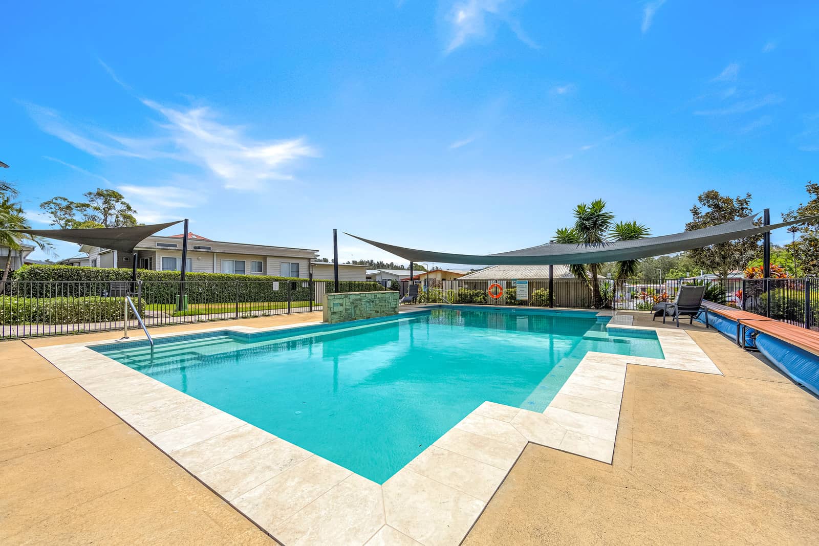 Ingenia Lifestyle community swimming pool with shaded areas and lounge chairs.