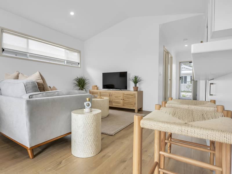 A light-filled living area in an Ingenia Lifestyle community home, featuring a sofa and bar stools.