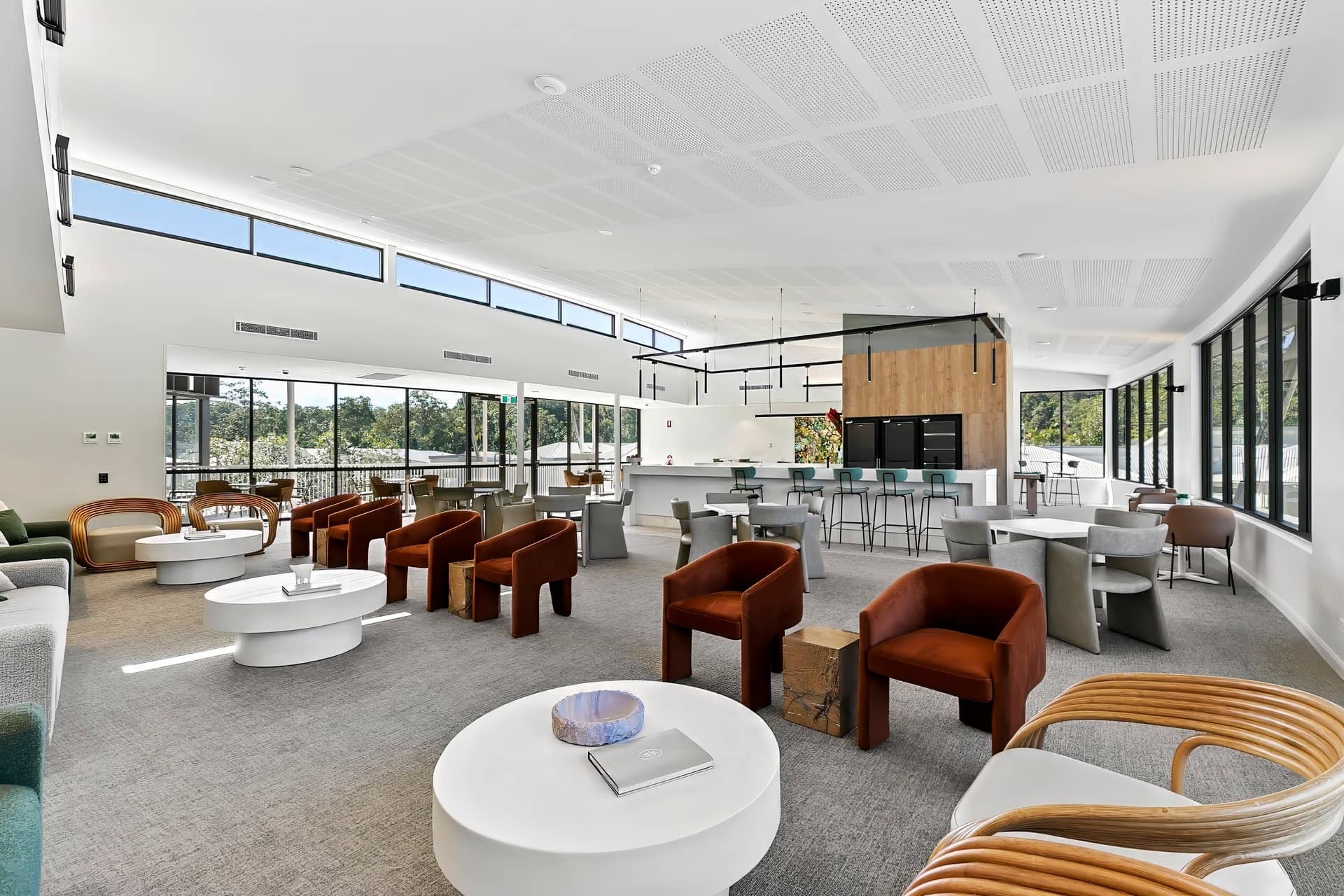 Spacious, modern community lounge at an Ingenia Lifestyle community with diverse seating, a bar, and large windows.