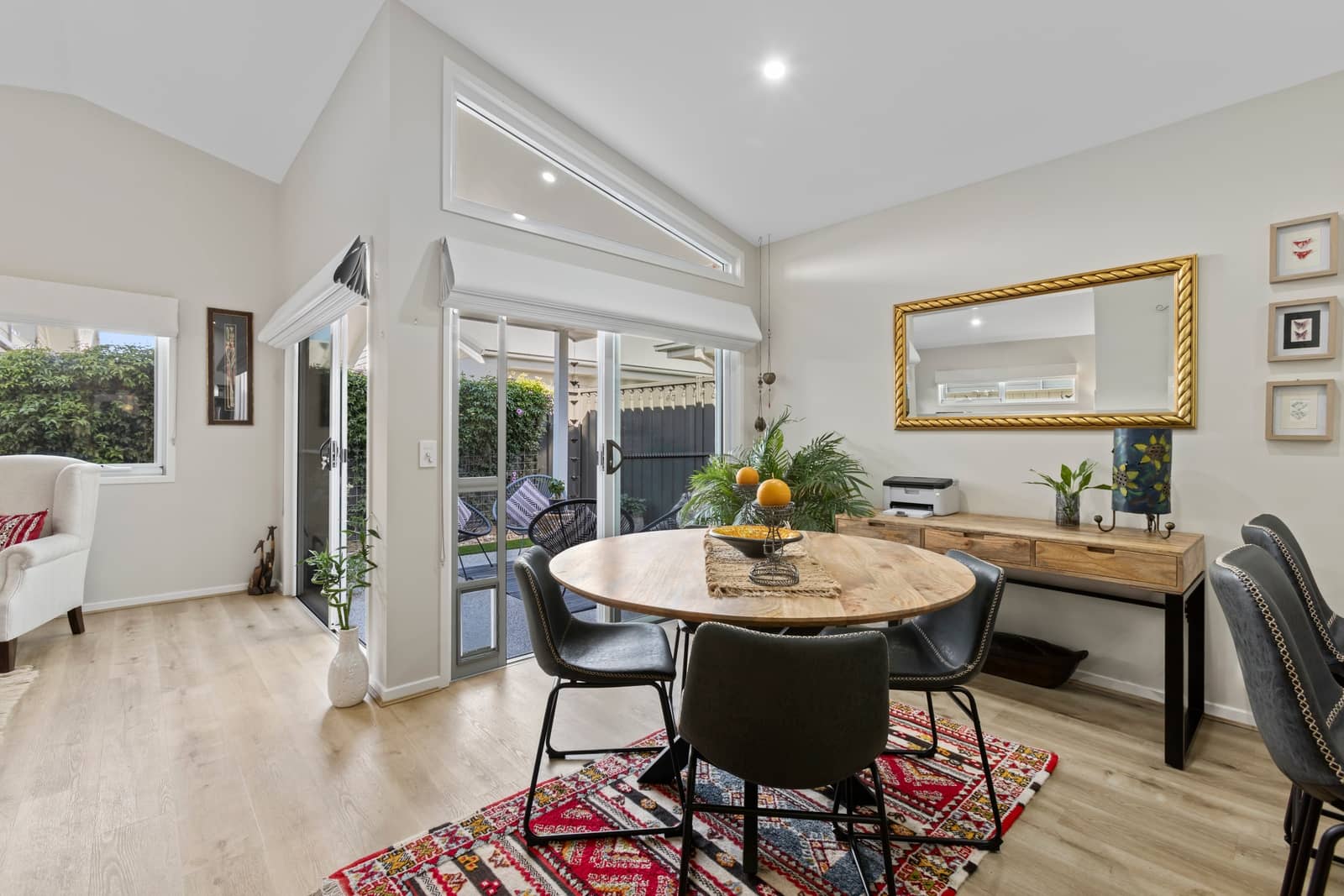 Round wooden dining table with four chairs and patterned rug in Ingenia Lifestyle home.