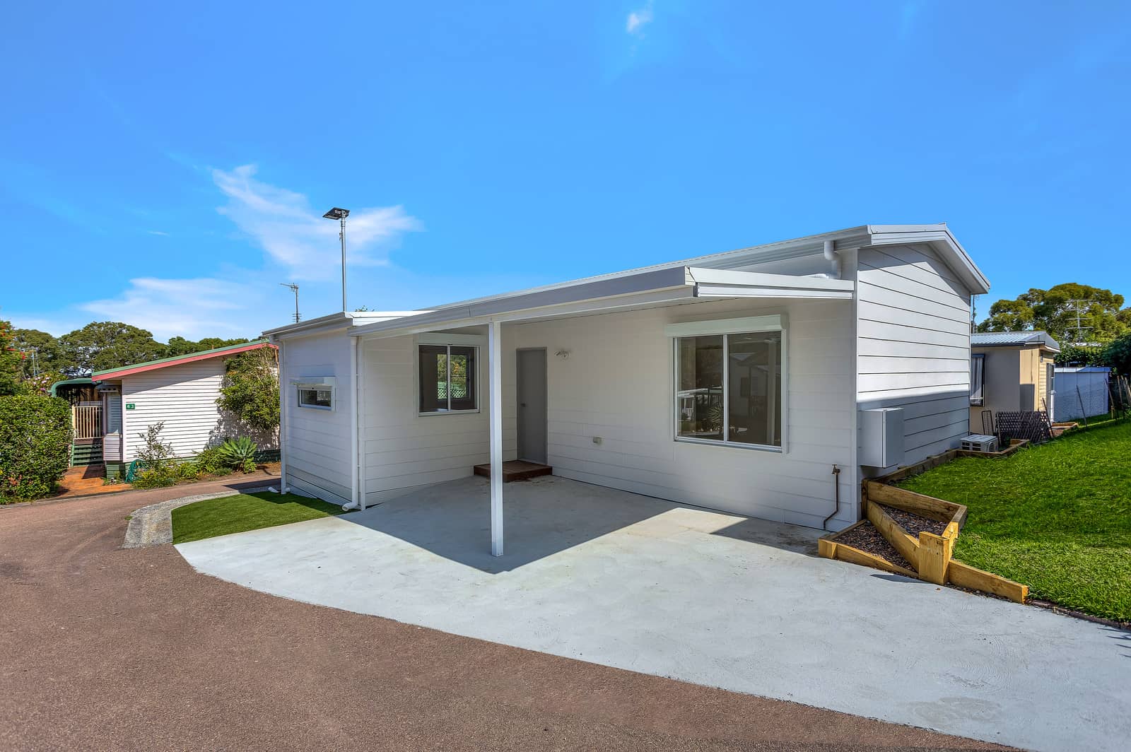White land-lease home with covered carport and driveway in an Ingenia Lifestyle community.