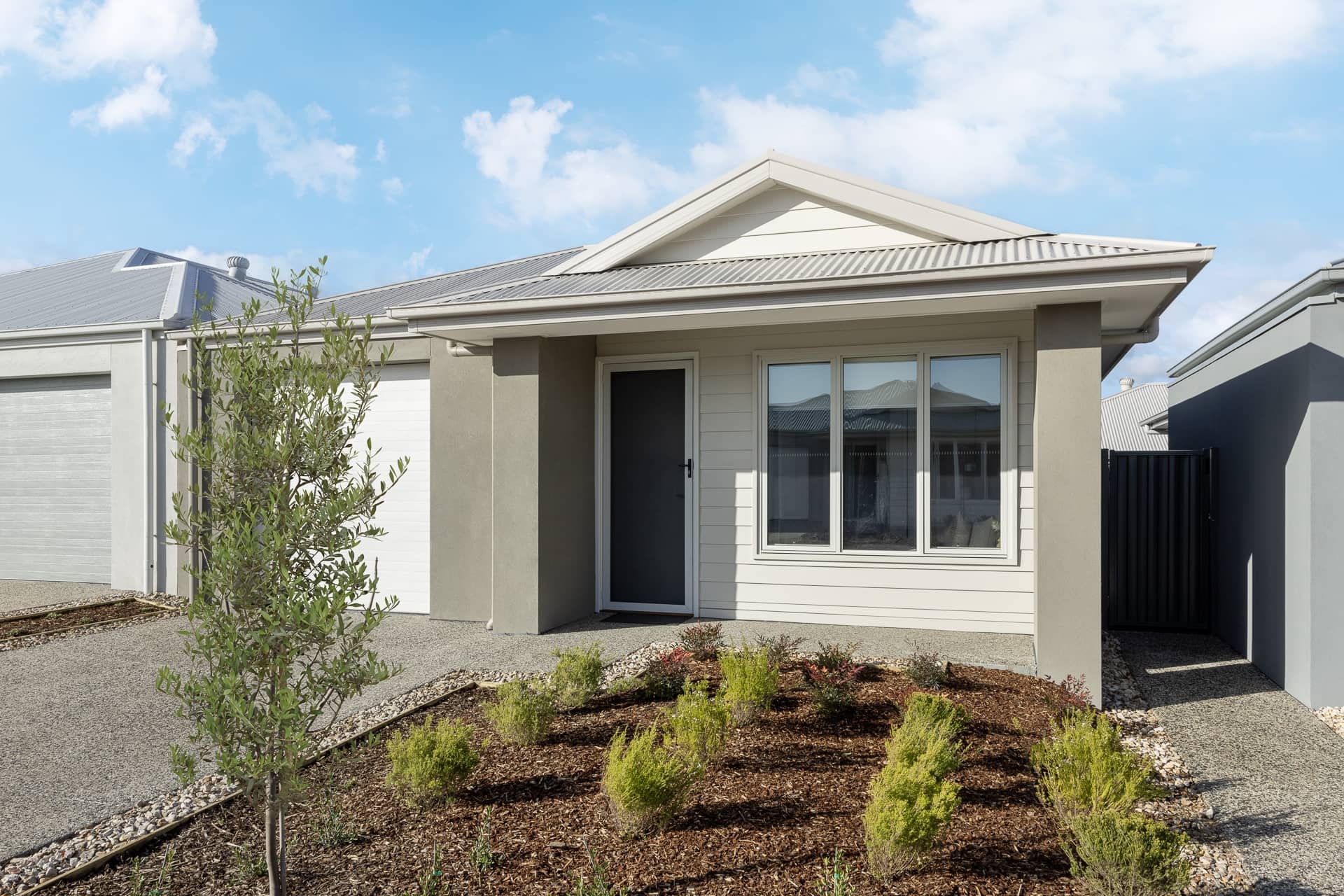 Modern land lease home in an Ingenia Lifestyle community with light-colored siding, a grey roof, and low-maintenance landscaping.