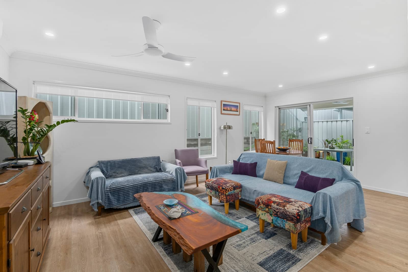 A bright, open plan living and dining space in an Ingenia Lifestyle home, featuring comfortable sofas, wood-look flooring, and natural light.