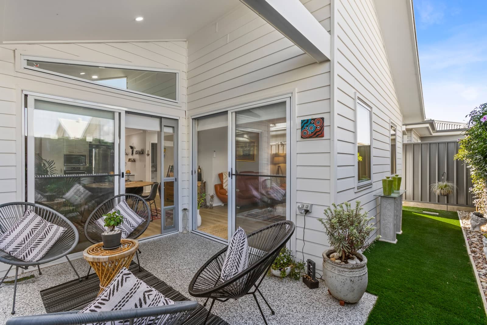 Outdoor patio area of a land lease home with chairs, tables, and artificial turf.