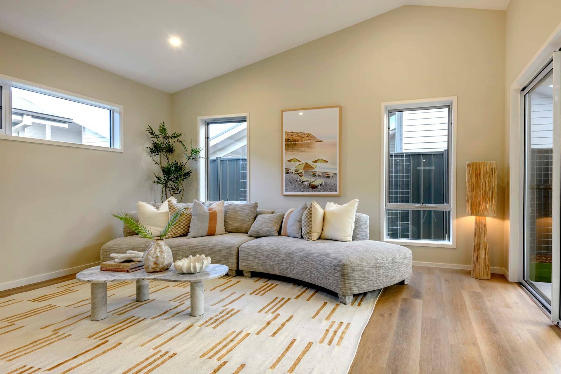 Living room with a sectional sofa, coffee table, and artwork. Ingenia Lifestyle community.