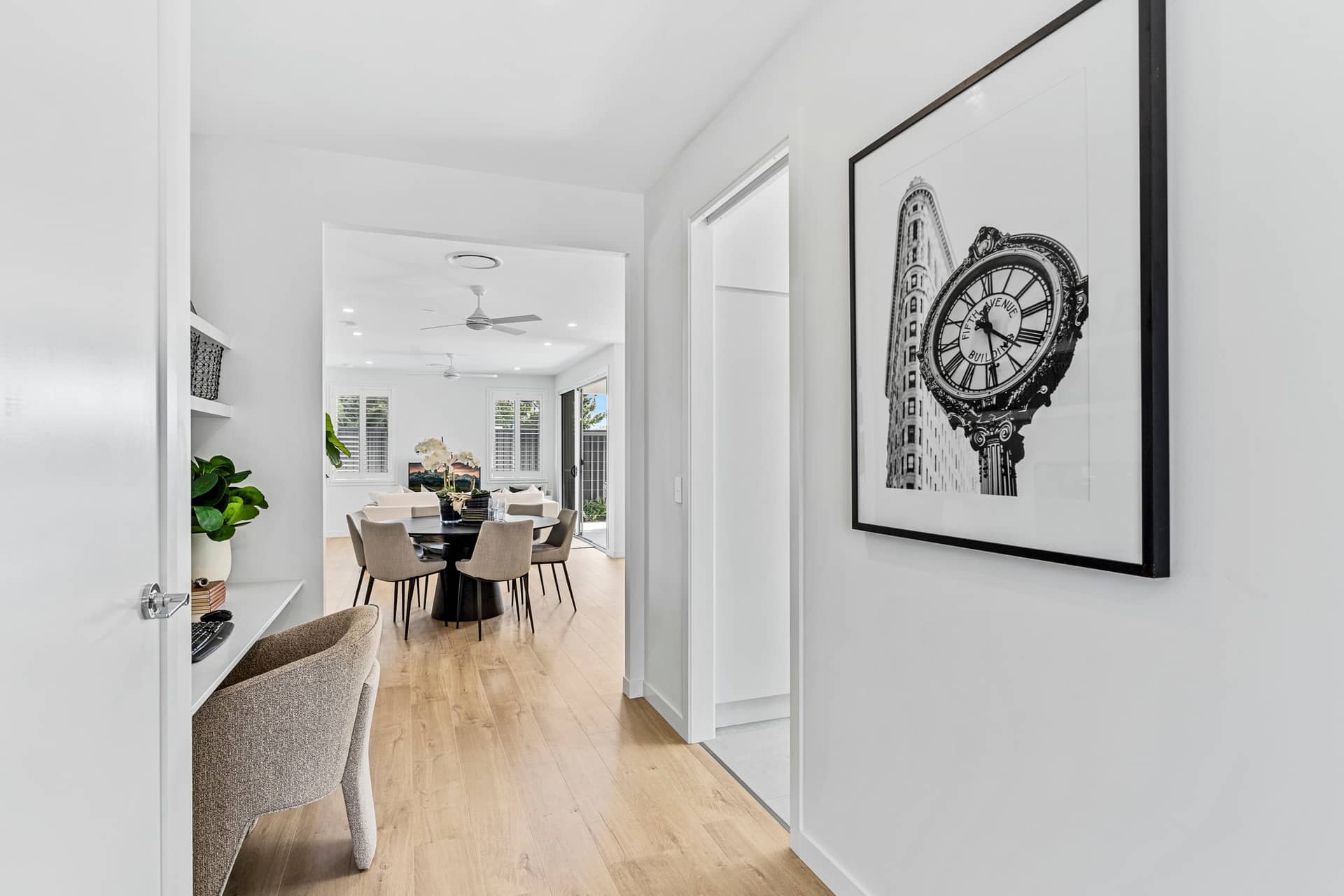Hallway with a desk and chair, leading to a dining area with a round table and chairs.