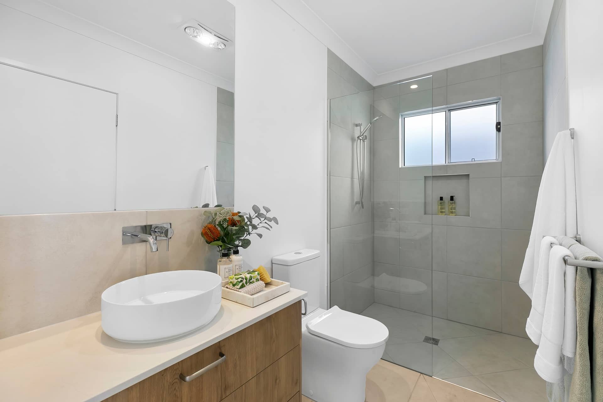 Modern bathroom in an Ingenia Lifestyle home, with timber-look vanity, basin, toilet, and tiled walk-in shower.