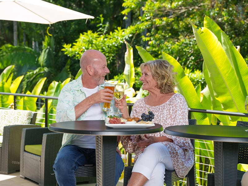 Couple sitting at outside community bar enjoying a drink- Ingenia Lifestyle Nature's Edge