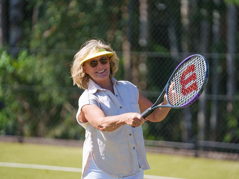 Active lady playing a game of tennis at over 50s lifestyle community - Ingenia Lifestyle Nature's Edge