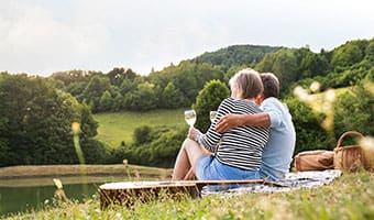 over 55s couple sitting together having a picnic